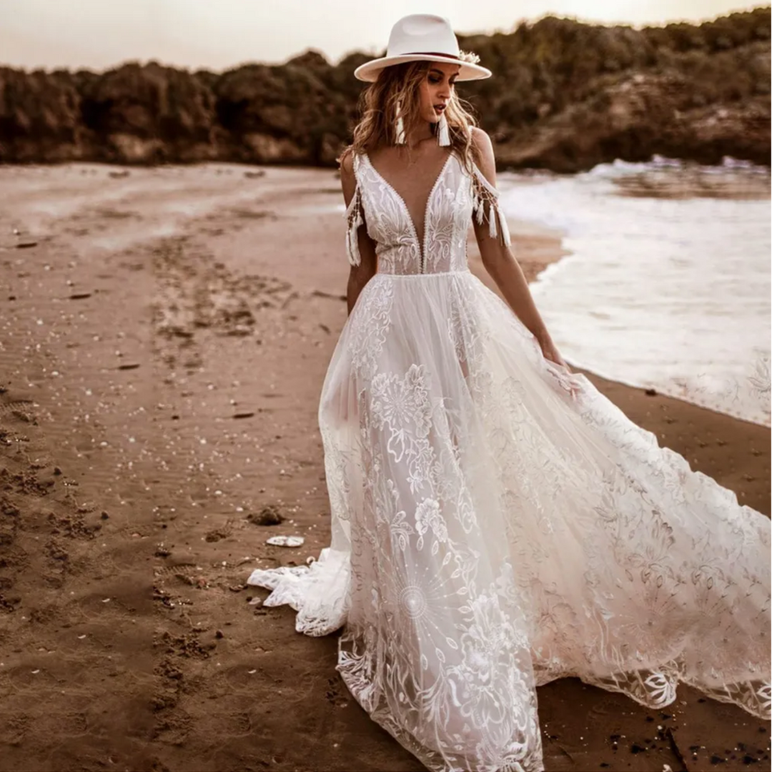 Boho-meets-modern bridal gown: V-neck, embroidery, open sides, low back, lace & A-line silhouette.