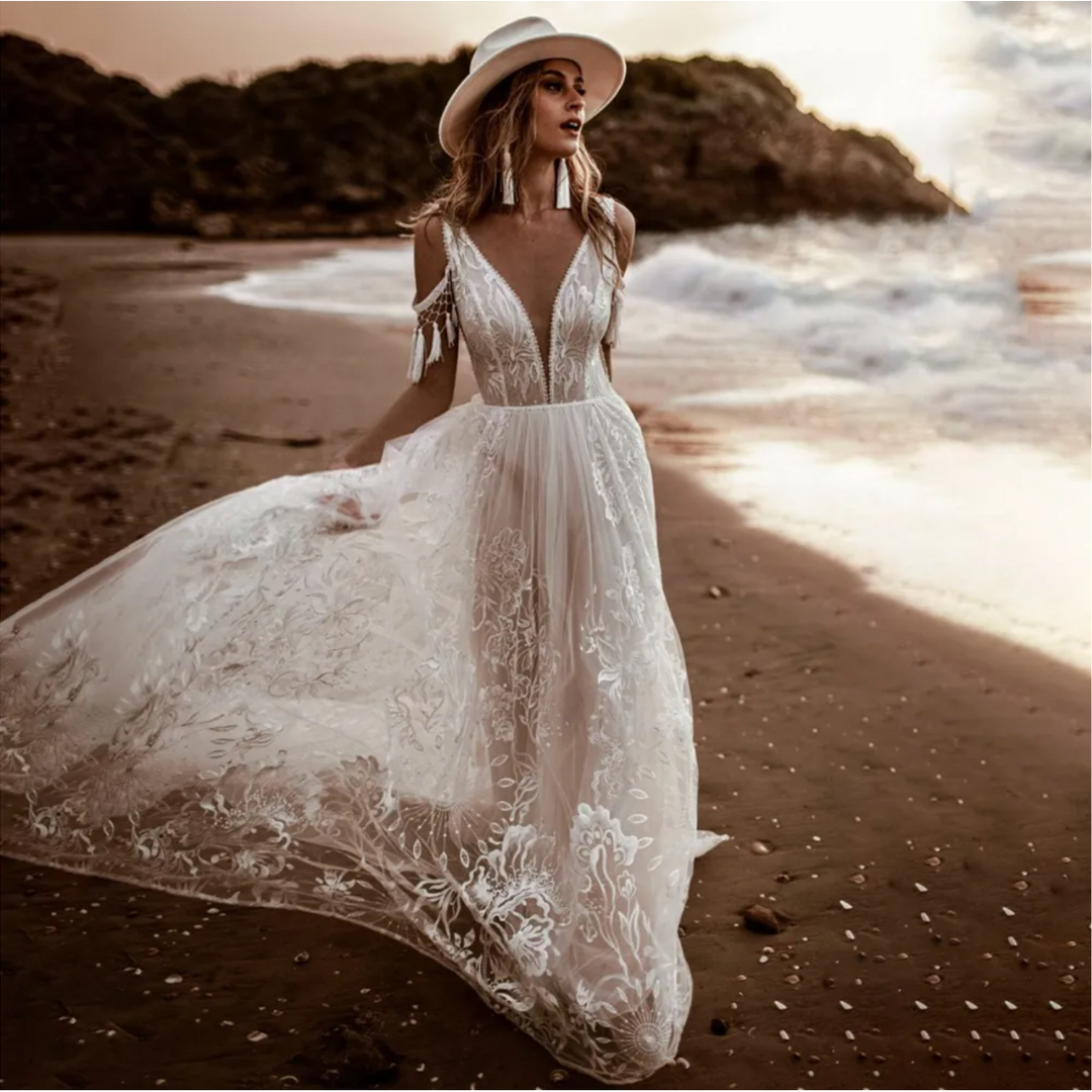 Boho-meets-modern bridal gown: V-neck, embroidery, open sides, low back, lace & A-line silhouette.