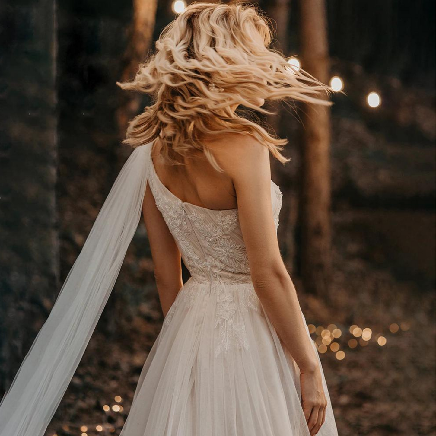 One-shoulder boho wedding gown: ruched bow, lace & tulle, A-line, built-in bra, sweep train.