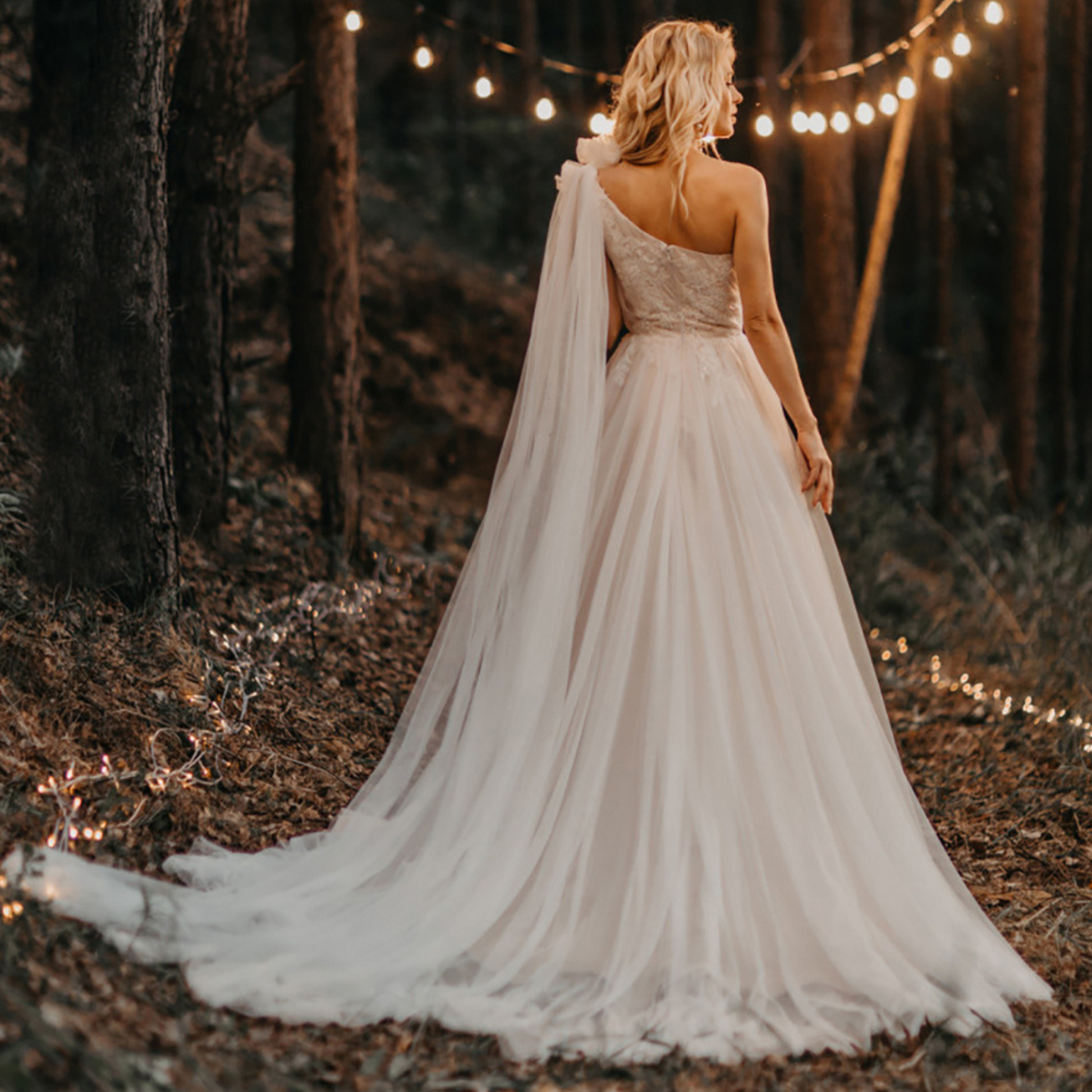 One-shoulder boho wedding gown: ruched bow, lace & tulle, A-line, built-in bra, sweep train.