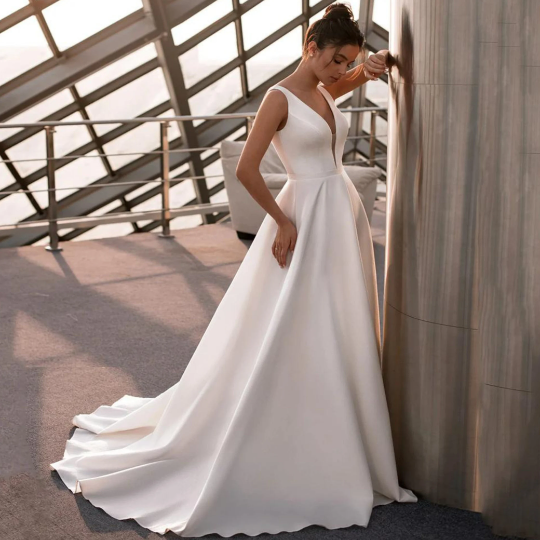 Beautiful simple sleeveless A-Line gown for Wedding Bride Beach in Satin, with deep V neck and backless crossover design. In White. - Bella Grace